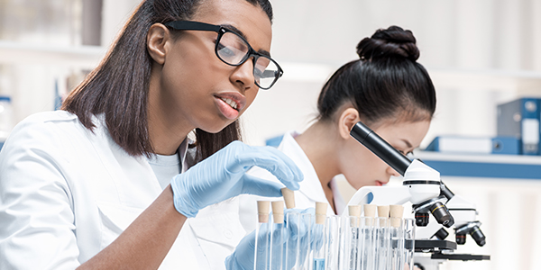 Two women scientists working in a lab setting.